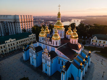 Buildings in city against sky during sunset