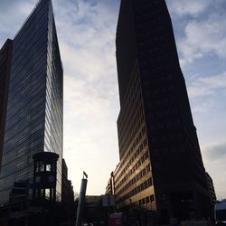 Low angle view of buildings against cloudy sky