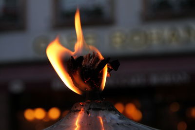 Close-up of lit candle burning in temple