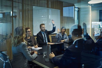 Group of business people voting during meeting