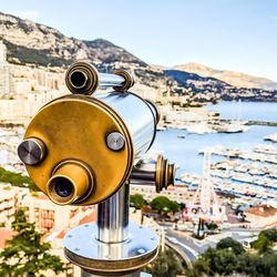 Close-up of coin-operated binoculars against cityscape