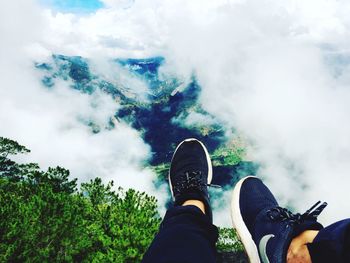 Low section of man against cloudy sky