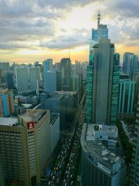 Cityscape against cloudy sky at sunset