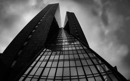 Low angle view of modern building against cloudy sky