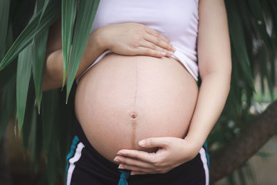 Midsection of pregnant woman touching stomach