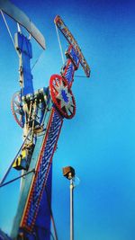 Low angle view of carousel against clear blue sky