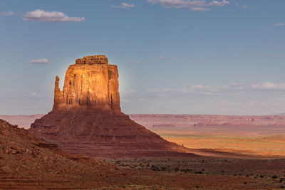 Rock formations on landscape against cloudy sky