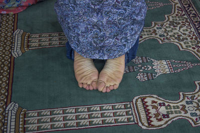 Low section of person kneeling on carpet