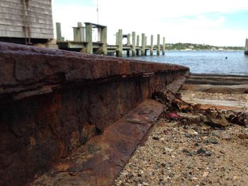 Close-up of built structure by sea against sky