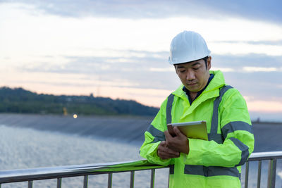 Side view of man standing against lake