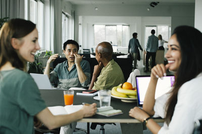 Business colleagues gesturing and talking to each other during meeting at office