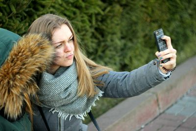 Woman talking selfie using phone in park