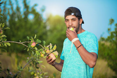 Portrait of young man standing against plants