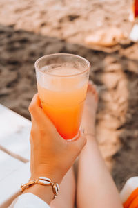 Midsection of woman holding drink glass