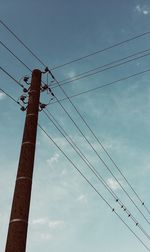 Low angle view of electricity pylon against sky