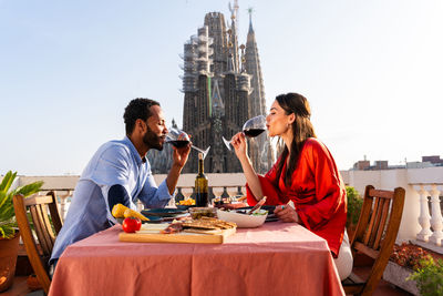 Young woman using mobile phone while sitting at restaurant