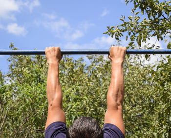 View of man hanging from metal bar