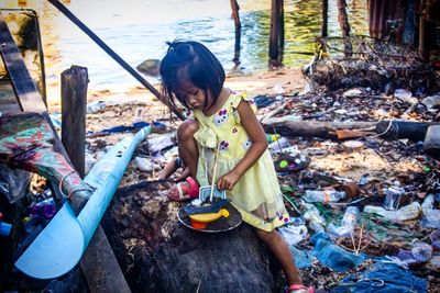 High angle view of girl playing with toys while sitting outdoors