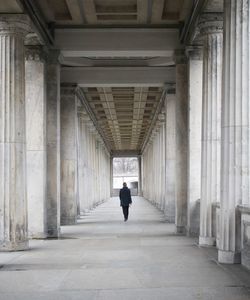 Rear view of man walking in corridor of building