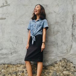 Young woman standing against wall