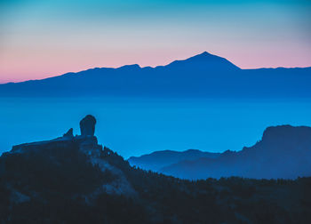 Scenic view of silhouette mountains against sky during sunset