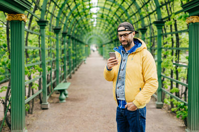 Young man using mobile phone standing outdoors