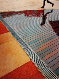 Low section of man standing by swimming pool