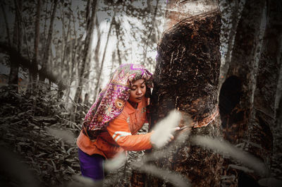 Woman with arms raised in forest