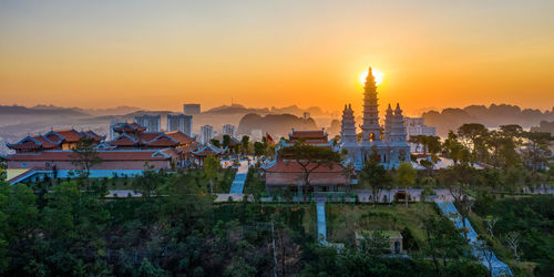 Illuminated buildings against sky during sunset