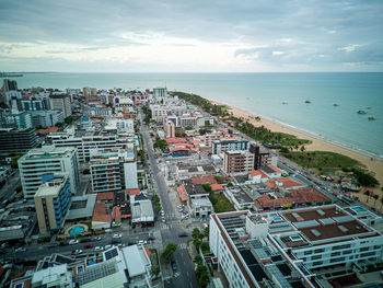 High angle view of townscape by sea against sky