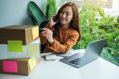 Portrait of young woman using laptop on table