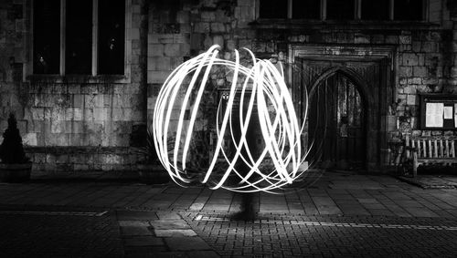 Light trails on street against building at night