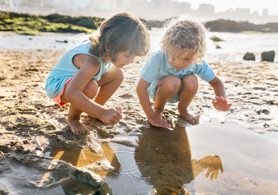 Little boy and girl playing together on the beach