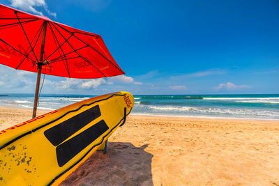 Close-up of deck chairs on beach against sky