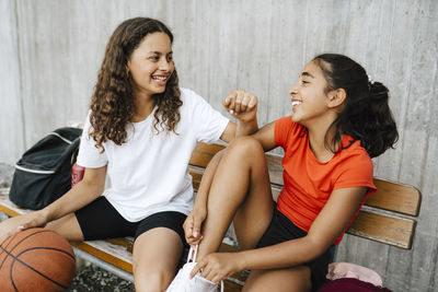 Happy girls spending leisure time at basketball court