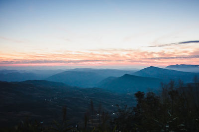 Scenic view of silhouette mountains against sky at sunset