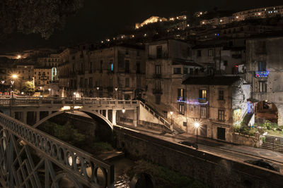 Illuminated bridge over river at night