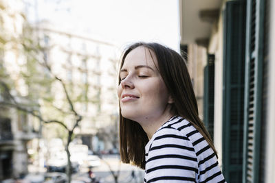 Portrait of young woman looking away outdoors