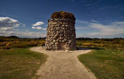 Stone structure on field against sky