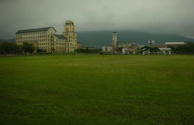 Building on grassy field against sky