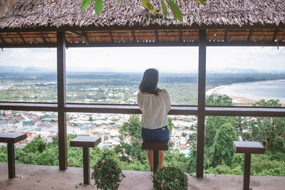 Rear view of woman standing by railing