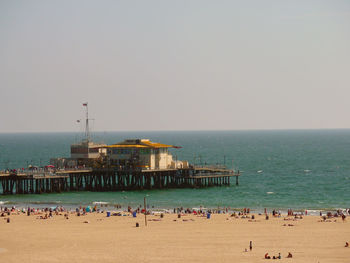 People on beach against clear sky