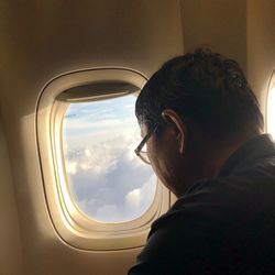 Portrait of man looking through airplane window