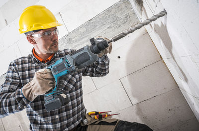 Man drilling with machine in wall