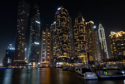 Illuminated modern buildings against sky at night