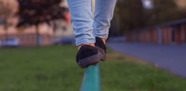 Boy walking along the road fence. child keeps balance on the log