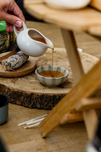 Cropped hands of woman holding coffee on table