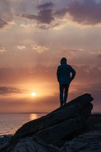 Rear view of man looking at sea against sky