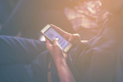 Midsection of man using mobile phone