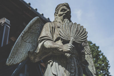 Low angle view of angel statue against sky